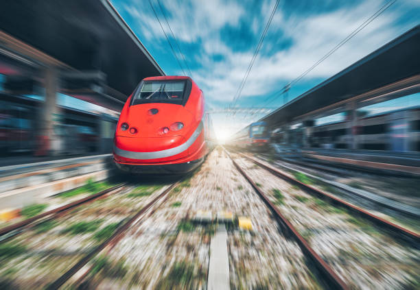 istock High speed train in motion on the railway station at sunset. Fast red modern intercity train and blurred background. Railway platform. Railroad in Italy. Commercial. Passenger railway transportation 1633435587