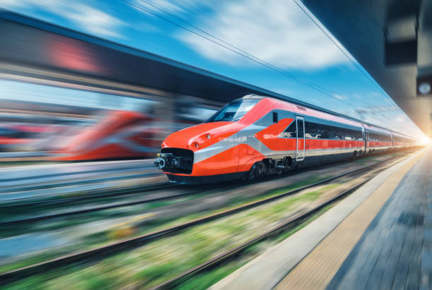 istock Red high speed train in motion on the railway station. Fast moving modern intercity train and blurred background. Railway platform. Railroad in Italy. Commercial and passenger railway transportation 1633435598