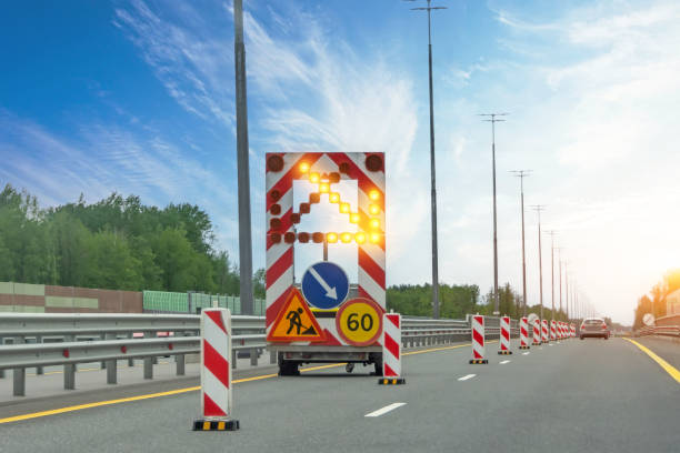 véhicule de services routiers avec remorque et limite de vitesse et panneaux d’avertissement d’entretien de voie, une flèche lumineuse indiquant une voie fermée. - vehicle trailer flash photos et images de collection