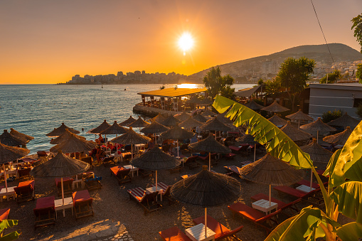 Beautiful resort with umbrellas by the sea at sunset in Sarande or Saranda on the Albanian riviera, Albania