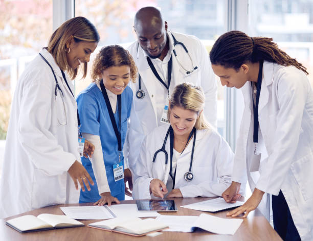 istock Doctors group discussion, tablet and desk with documents, results or report with teamwork, good news and support. Team, touchscreen and big data analysis for progress, development or medical research 1633439031