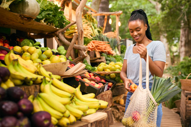 istock Female Customer At Market Stall Choosing Fresh Fruit And Vegetables 1633442160
