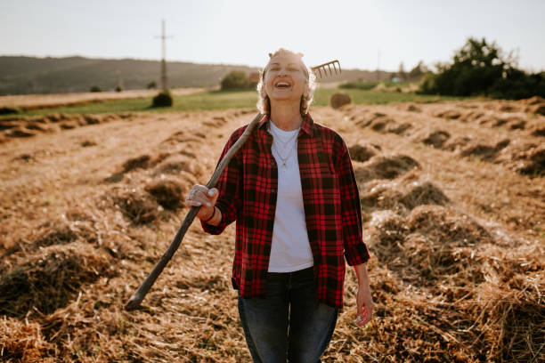 Medium shot of confident woman farmer looking at camera standing in organic vegetable garden