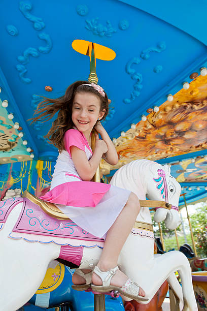 istock Girl riding on carousel horse laughing 163344778