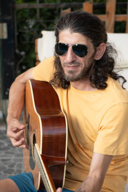 Young musician plays guitar in the pool