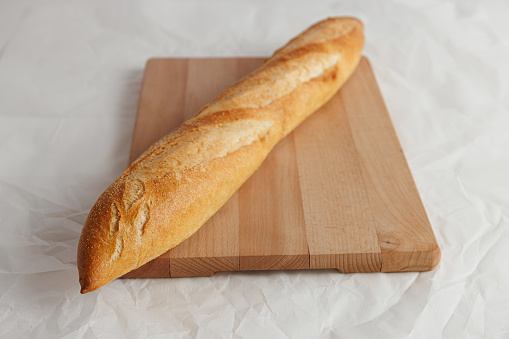 Fresh whole grain bread cut in half on white background