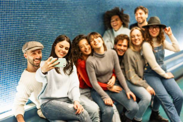 istock Group of young friends taking selfie inside metropolitan city subway while waiting for train - Generation Z lifestyle and friendship concept - Focus on smartphone 1633459879