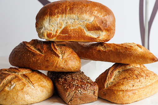 Variety of bread, beautifully baked loaves with golden crust stacked