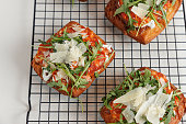 Puff pastry with tomato, arugula and grana cheese on top