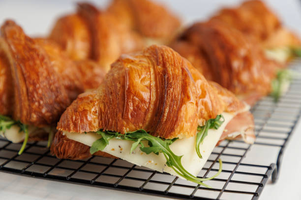 istock Close-up on croissants on serving grid filled with prosciutto, cheese and arugula 1633463535
