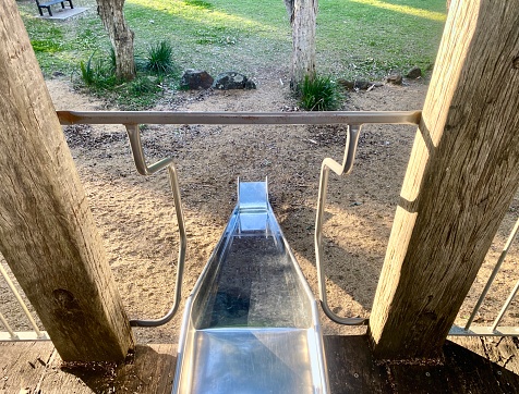 Horizontal looking down to metal and wood slippery slide in children’s public park in country Bangalow Australia