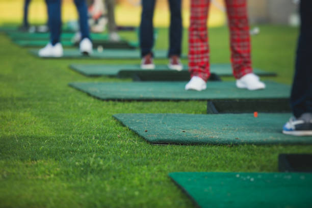 istock Group of golfers practicing and training golf swing on driving range practice, men playing on golf course, golf ball at golfing complex club resort 1633464099