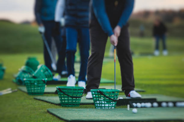 kelompok pegolf berlatih dan melatih ayunan golf pada latihan driving range, pria bermain di lapangan golf, bola golf di resor klub kompleks golf - golf olahraga potret stok, foto, & gambar bebas royalti