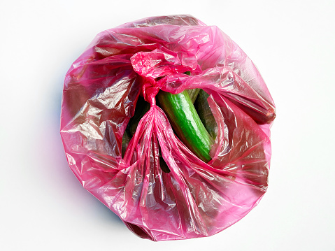 Cucumbers in plastic shopping bag on white background