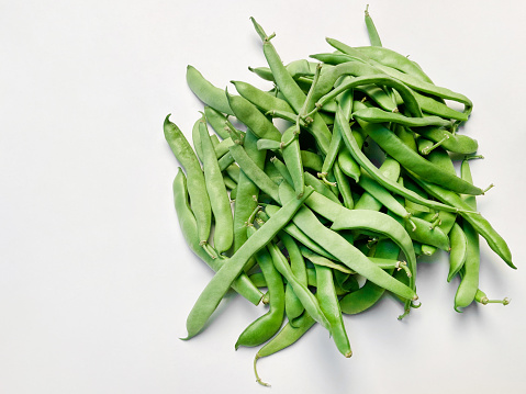 High angle view fresh organic green beans on white background with copy space
