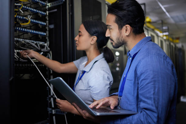 istock Man, woman or server room maintenance on laptop IT, software programming ideas or cybersecurity engineering. People, repair or data center technology in teamwork collaboration of safety analytics fix 1633491902