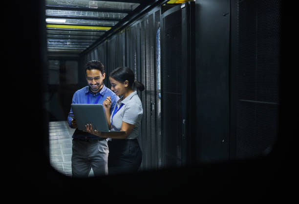 istock Server room, technician people and laptop for software management, system upgrade or cyber security. Teamwork, data center and engineer or programmer employees, information technology and programming 1633491915