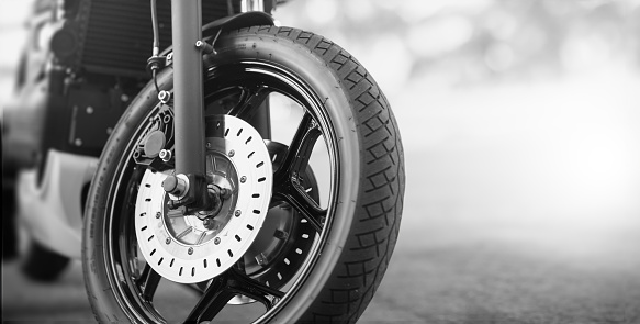 Front wheel of parked motorcycle, black and white image with copy space on the right area