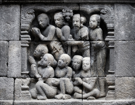 Detail of traditional asian Buddhist carved relief at Borobudur temple on Java, Indonesia