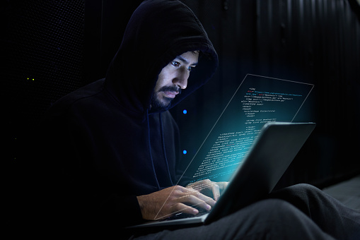 Cyber security, crime and hacker with laptop coding malware in data center stealing sensitive digital information. Technology, software and man hacking in database to update ransomware on website.