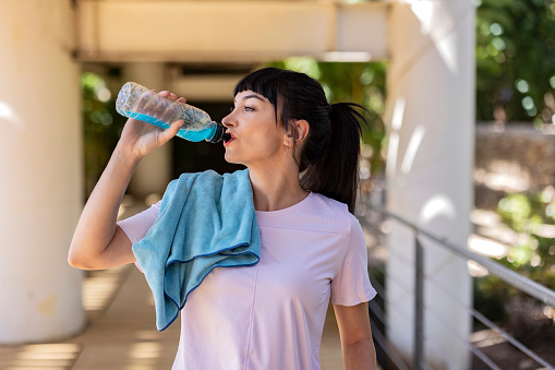 beautiful young woman drinking energy drink after doing sports