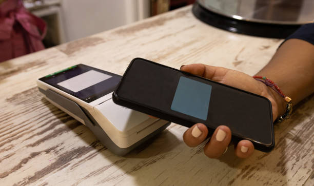 istock woman is paying with a phone in an establishment 1633529135