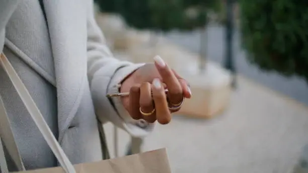 Hand holding house keys outside closeup. Real estate agent waiting rent client on city street. Unrecognized african american gesturing fumbling on phone conversation. Stylish girl commuting home.