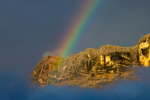 A Superb rainbow on cross mountain Monte croce Dolomites Alps near Alta Badia, Trentino-Alto-Adige region, Italy. Summer season.