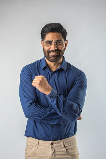 Portrait of handsome mid adult man smiling while standing isolated against white background