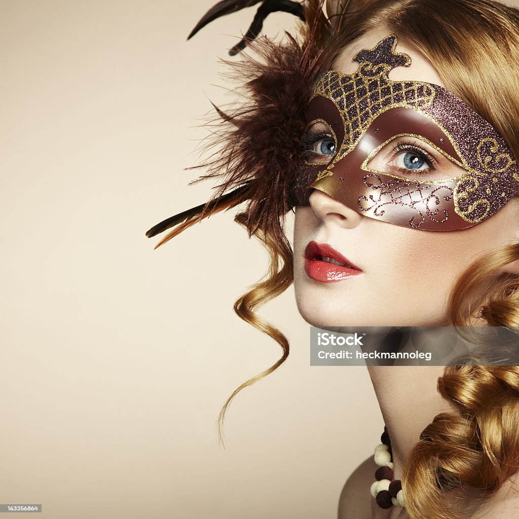 Beautiful young woman in brown mysterious venetian mask Beautiful young woman in brown mysterious venetian mask. Fashion photo Adult Stock Photo