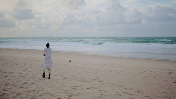 Thoughtful woman walking shore on winter day. Peaceful tourist watching ocean Thoughtful woman walking shore on winter day. Peaceful tourist watching ocean waves admiring nature on vacation. Unrecognized sad girl thinking making decision at calm place. Serenity tourism concept walking beach women sadness stock pictures, royalty-free photos & images