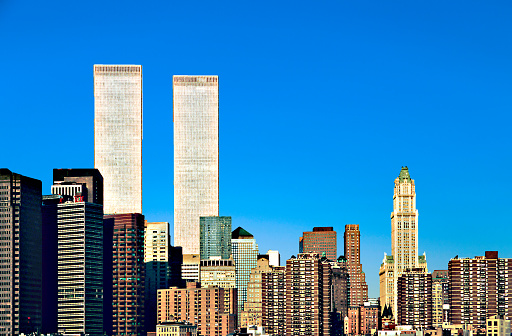 Amidst an azure canvas, the Twin Towers stood as icons in Manhattan's skyline, symbolizing architectural and economic prominence. This evocative scene, a remnant of an altered cityscape, carries poignant memories, signifying a changed era in urban history.