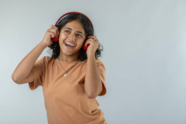 adolescente écoutant de la musique sur fond blanc - indian girls audio photos et images de collection