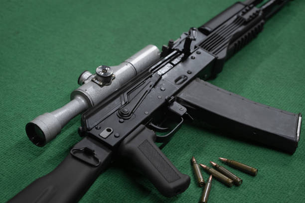 istock Rifle with an old-fashioned optical sight on a green surface with cartridges 1633596274