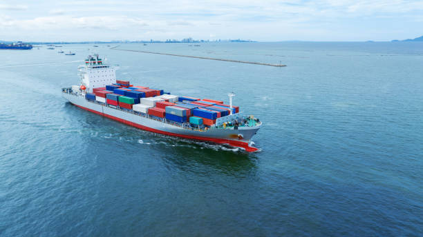 istock Aerial side view of  cargo container ship carrying container from custom container depot go to ocean concept freight shipping by ship service on blue sky .Freight Forwarding 1633601972