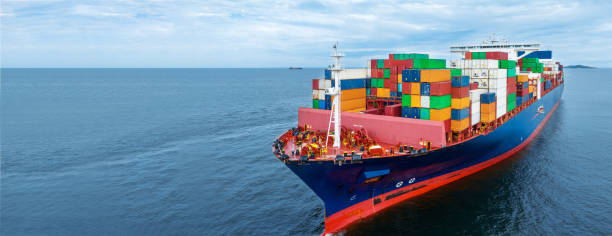 istock Aerial side view of  cargo container ship carrying container from custom container depot go to ocean concept freight shipping by ship service on blue sky .Freight Forwarding 1633602018