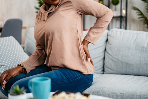 istock Young Woman Having Back Pain While Sitting On The Sofa At Home 1633606575