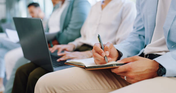 istock Recruitment, row and business people writing in notebook for hiring, job interview or work opportunity. Human resources, onboarding and candidates sitting with book, typing on laptop and write notes 1633613556