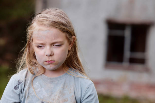 Dirty 'trailer trash' 8-year-old with brown eyes and a miserable face. Posed by model.