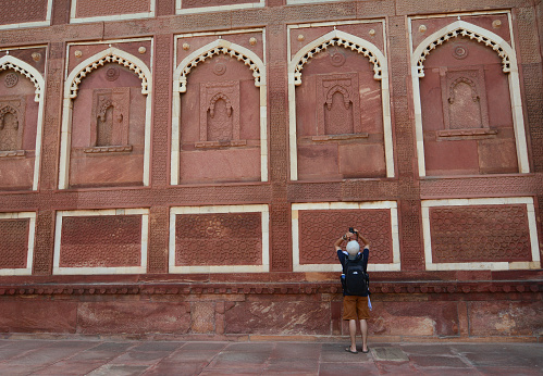 Agra, India - Jul 13, 2015. A man taking pictures at the Agra Fort in Agra, India. The fort was built by the Mughals, can be more accurately described as a walled city in Agra, India.