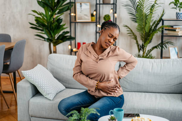 istock Young Woman Having Back Pain While Sitting On The Sofa At Home 1633632402