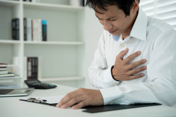 hand hold chest with heart attack symptoms, asian man working hard have chest pain caused by heart disease, leak, dilatation, enlarged coronary heart, press on the chest with a painful expression agarre la mano en el pecho con síntomas de ataque cardíaco, hombre asiático que trabaja duro tiene dolor en el pecho causado por enfermedad cardíaca, fuga, dilatación, agrandamiento del corazón coronario, presión sobre el pecho con una expresión do