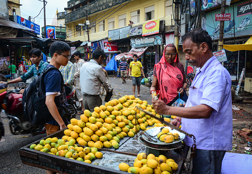 Varanasi, India - Jul 11, 2015. Vendors selling fresh mango fruits at old market in Varanasi, India. Varanasi draws Hindu pilgrims who bathe in the Ganges River sacred waters.