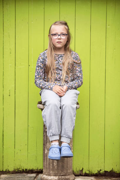 Girl of eight sitting on a pedestal - fotografia de stock