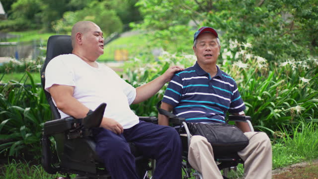 A man in a wheelchair encourage each other in a public park