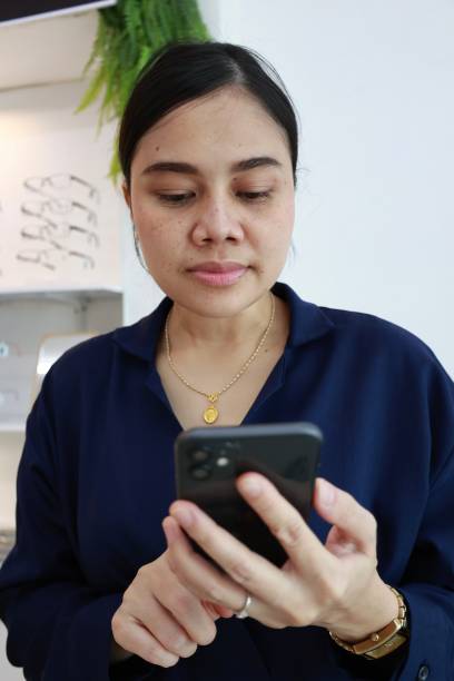 istock Woman using phone at optical store 1633688173