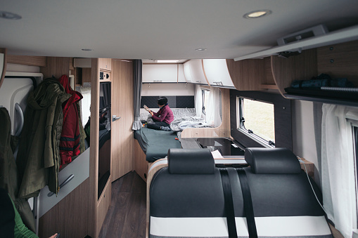 View of the interior of the caravan in the background a girl playing on the bed