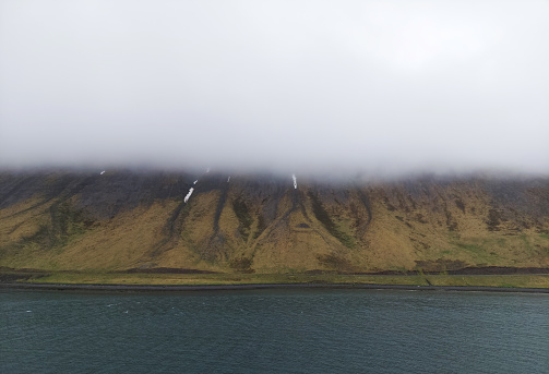 Misty fog over tranquil Icelandic landscape, showcasing the beauty of nature.