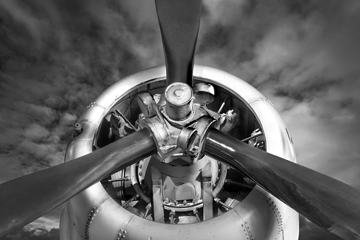 The image shows the nose of a Boeing B-17F WWII bomber.  The aircraft is parked on the ramp with a backdrop of a brooding, low overcast.  In black and white tones the photo presents a vintage, gritty quality like it was from the period.  The photo was taken at the Grant County International Airport in Moses Lake, WA.