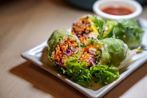 Spring roll made of rice paper filled with fresh vegetables, representing a delicious vegetarian food option.